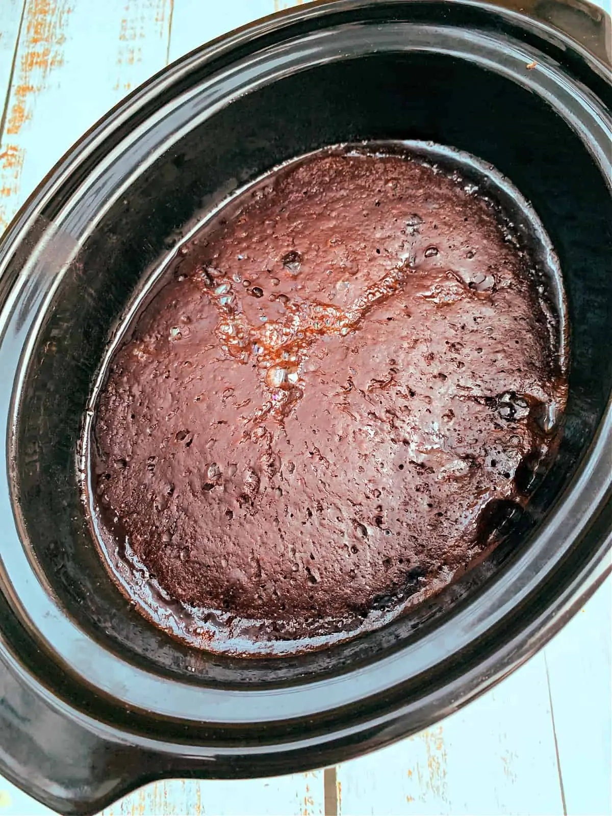 Chocolate orange pudding after baking, with a rich chocolate sponge cake layer over a chocolate sauce.