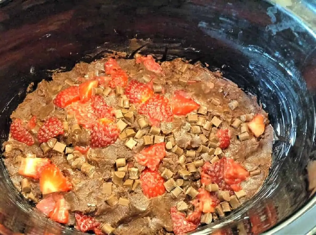 Chocolate and strawberry cookie dough in slow cooker pot.