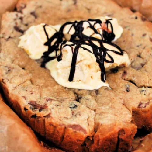Giant choc chip cookie served with vanilla ice cream and drizzles of chocolate sauce.