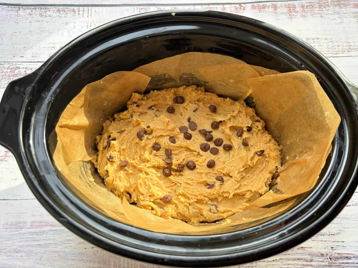 Cookie dough in lined slow cooker pot.