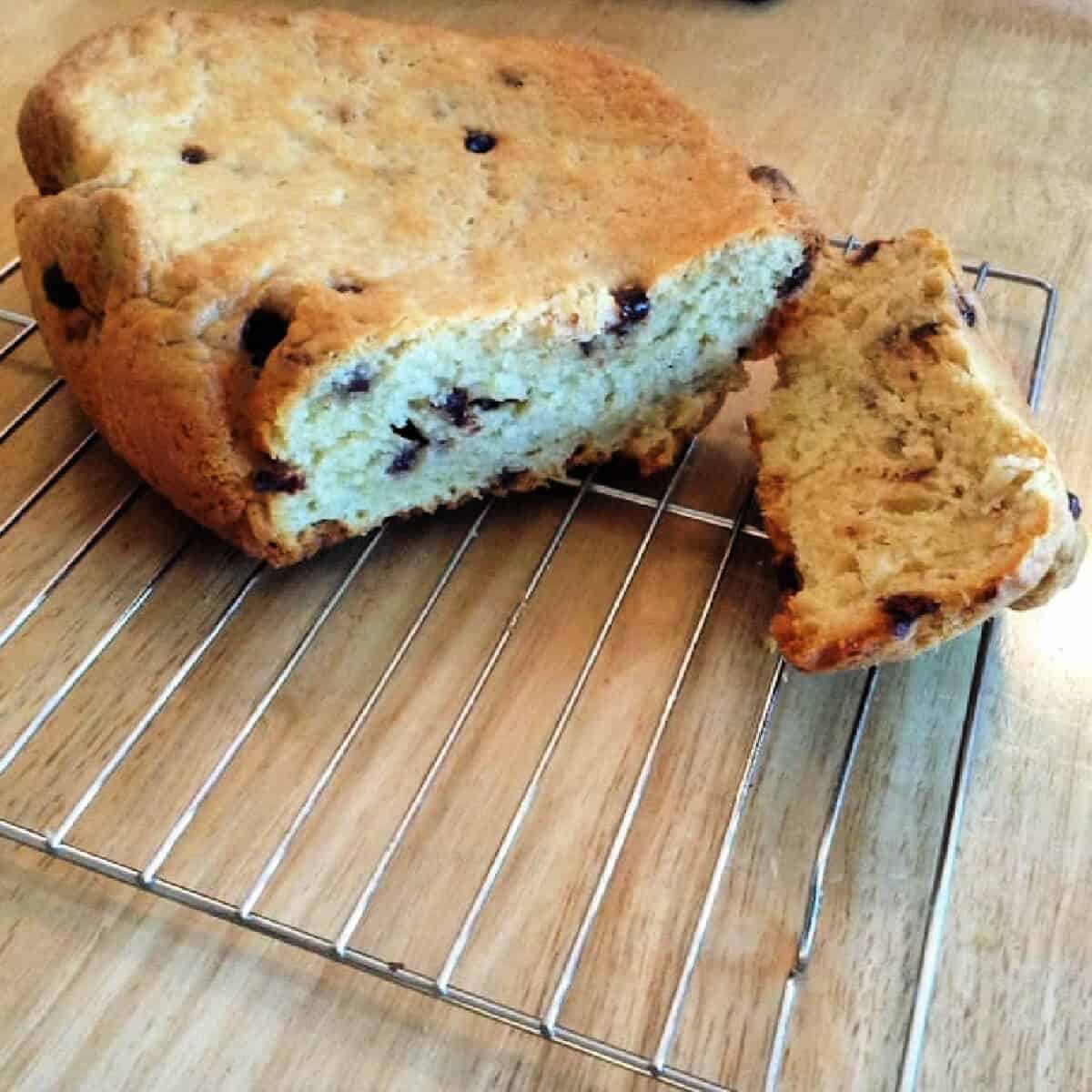 Brioche loaf with chocolate chips on a metal cooling rack.