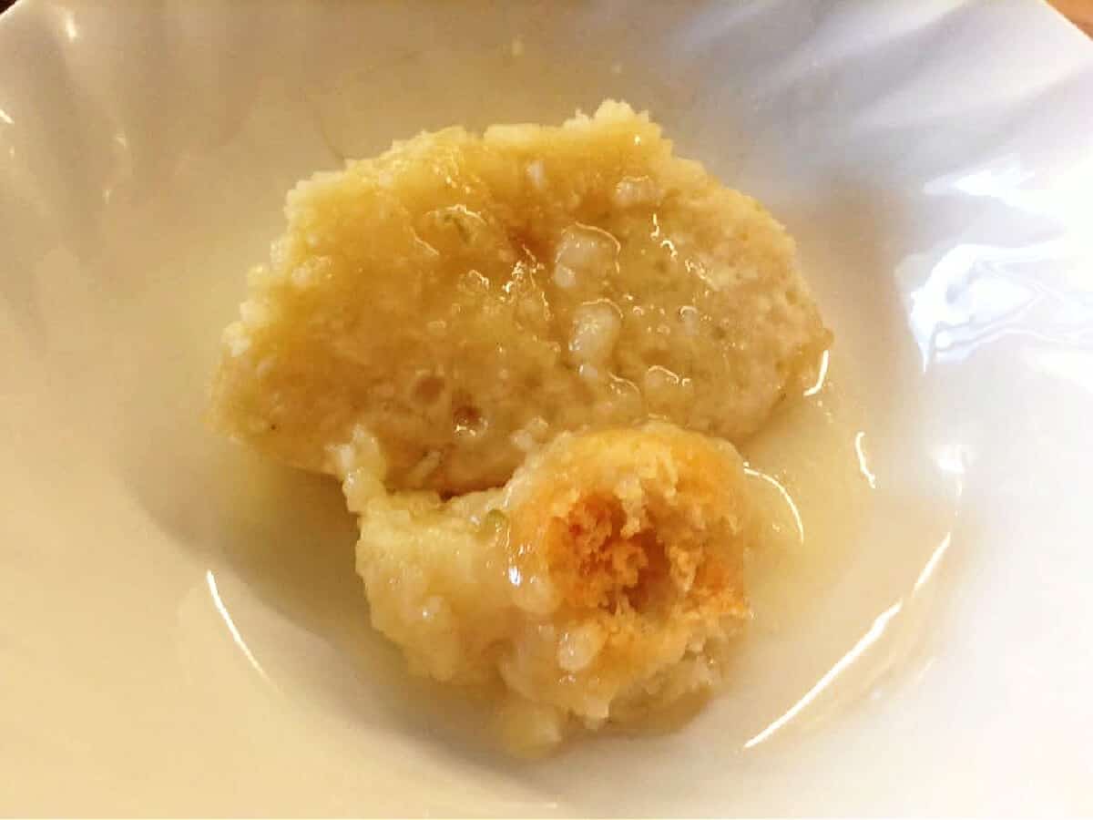 A portion of lime sponge with sauce in a white bowl.