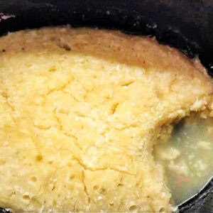 Coconut lime sponge pudding with sauce in slow cooker pot.