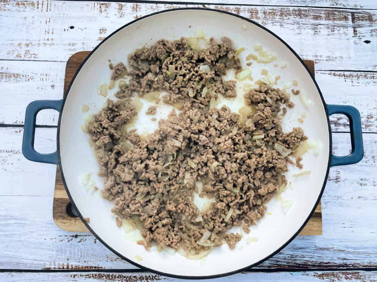 Saucepan with diced onion and lamb mince, browned.
