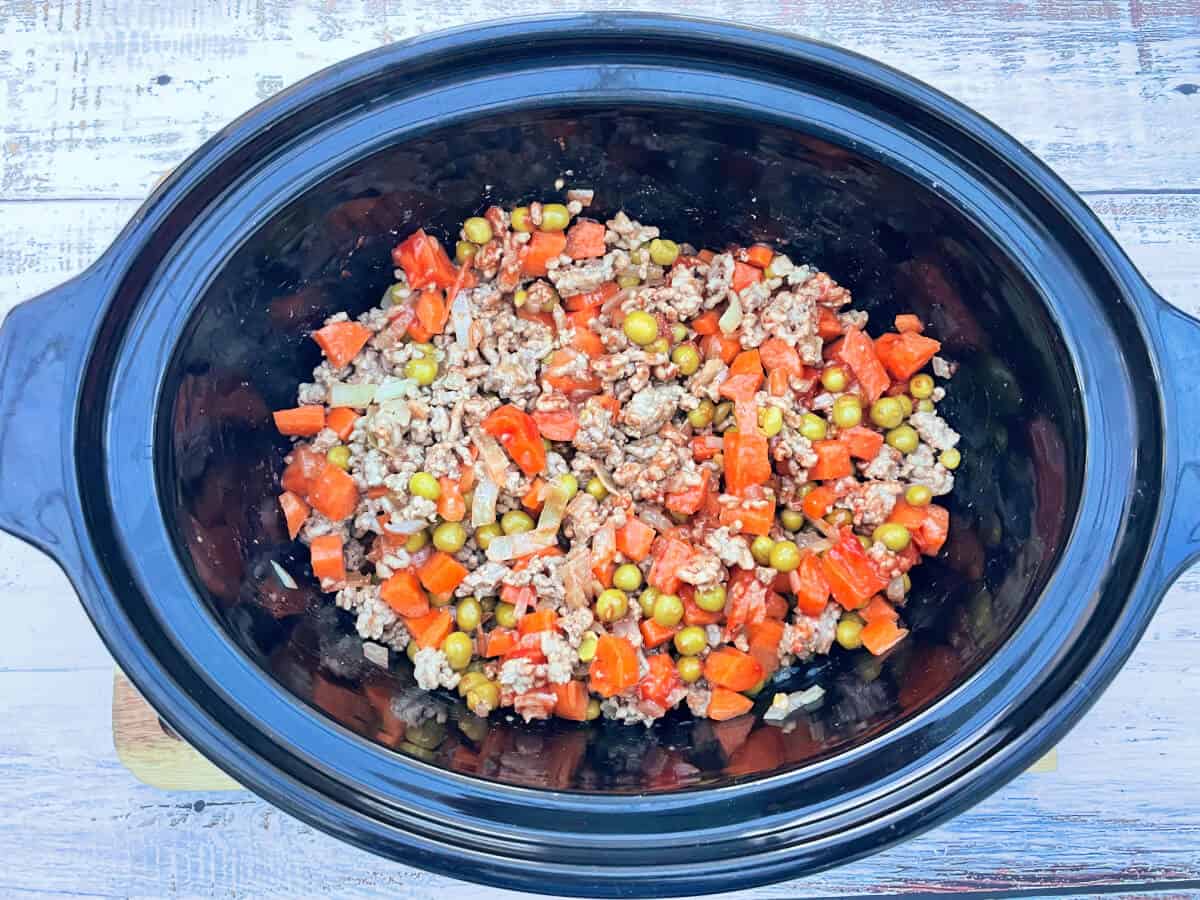 Mixed ingredients for sheperd's pie filling in slow cooker pot.