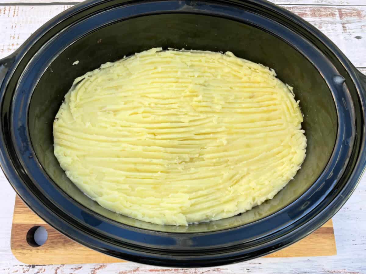 Slow cooker pot with shepherd's pie filling topped with mash.
