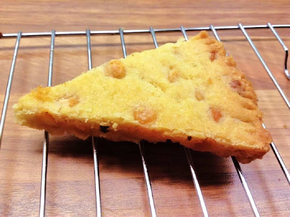 Triangular slice of shortbread on a cooling rack.