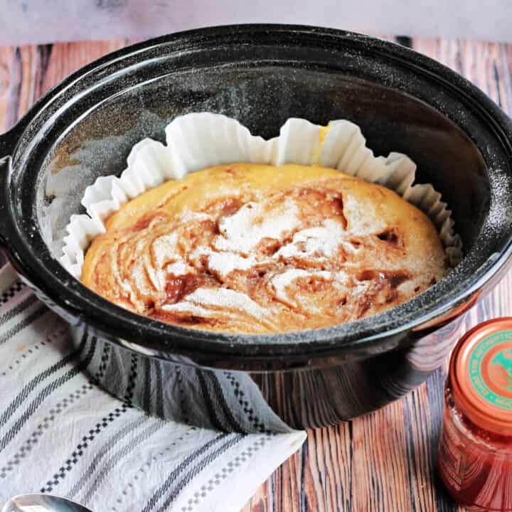 Jam sponge pudding in slow cooker pot.