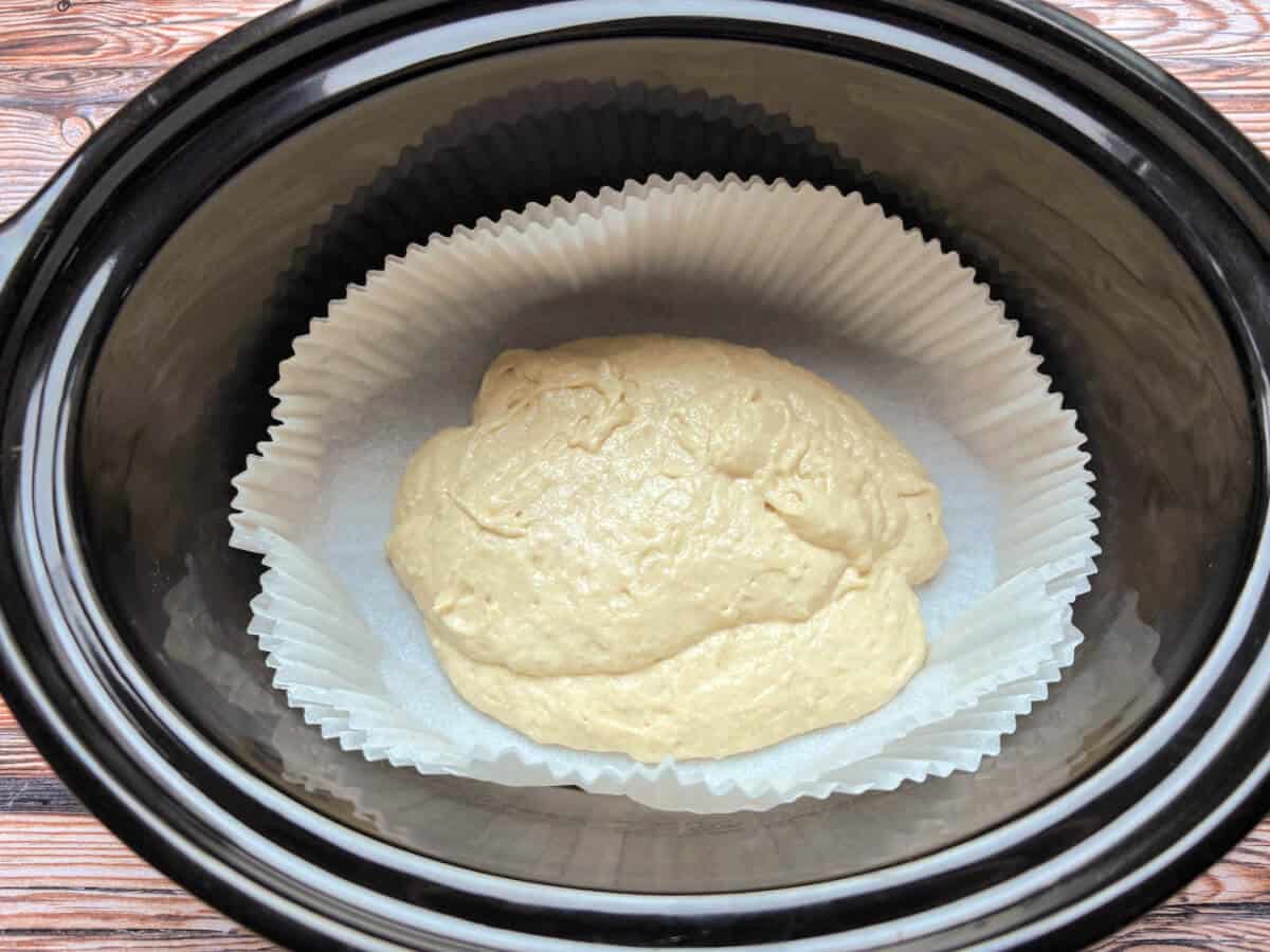 Cake mixture in slow cooker pot in a case.