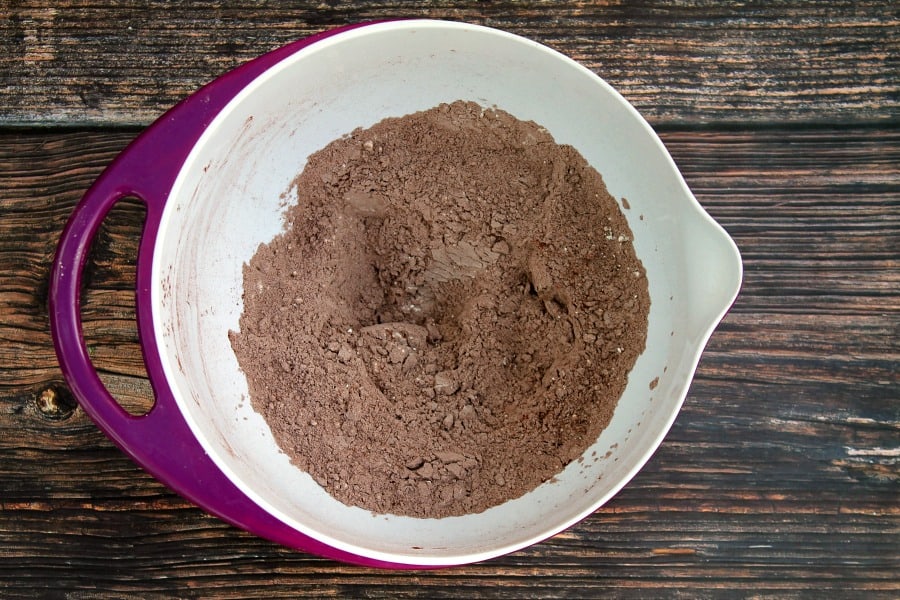 Flour and cocoa powder in a purple bowl.