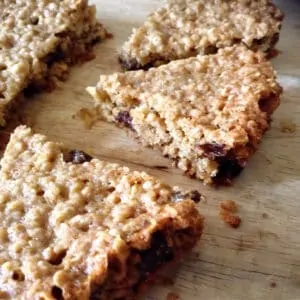 Close up of slices of oat bars on a wooden chopping board.