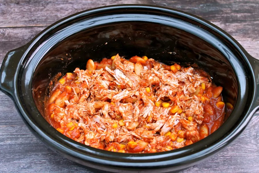 Shredded chicken in tomato sauce in a slow cooker.
