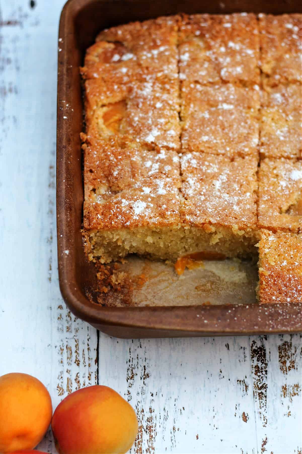 Baking pan with squares of cake cut out.