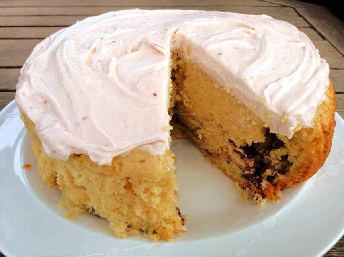 Cake on a white plate, with a slice cut out.