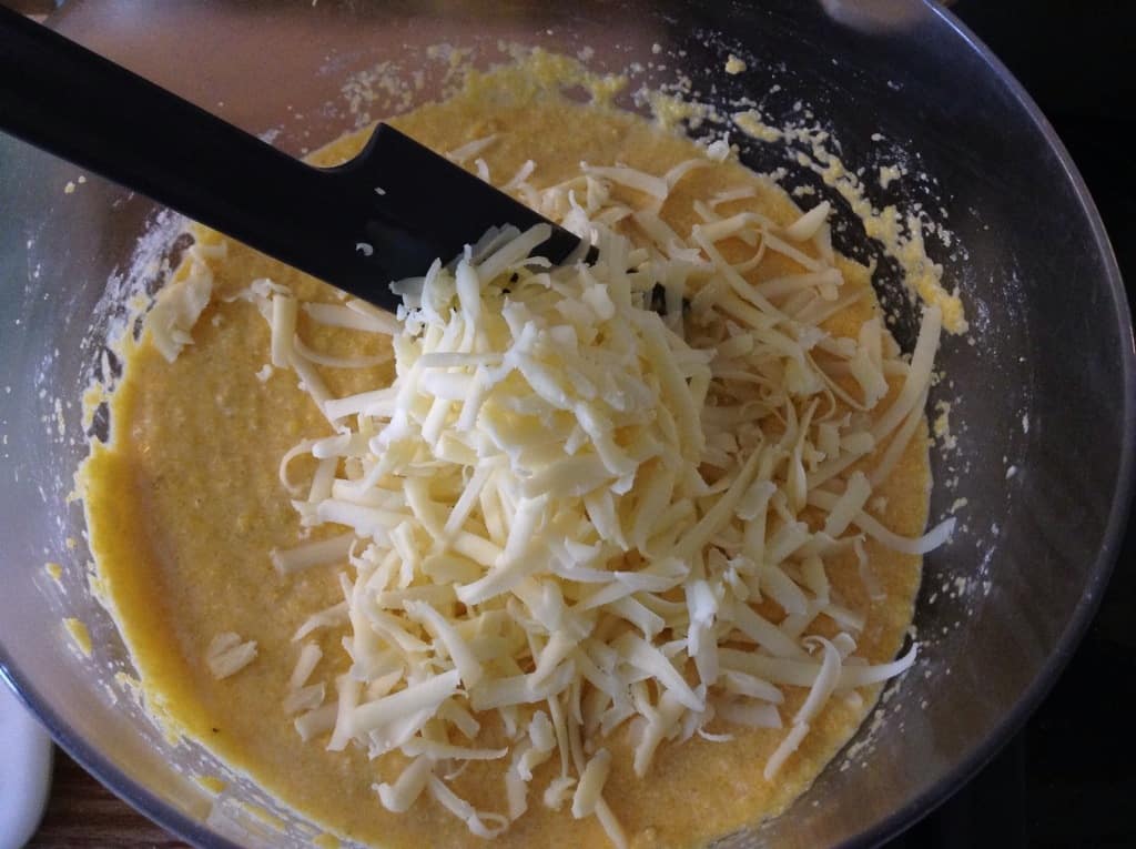 Bowl with corn mixture and grated cheese.