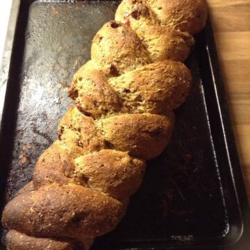 Braided loaf on baking tray, golden brown after baking.