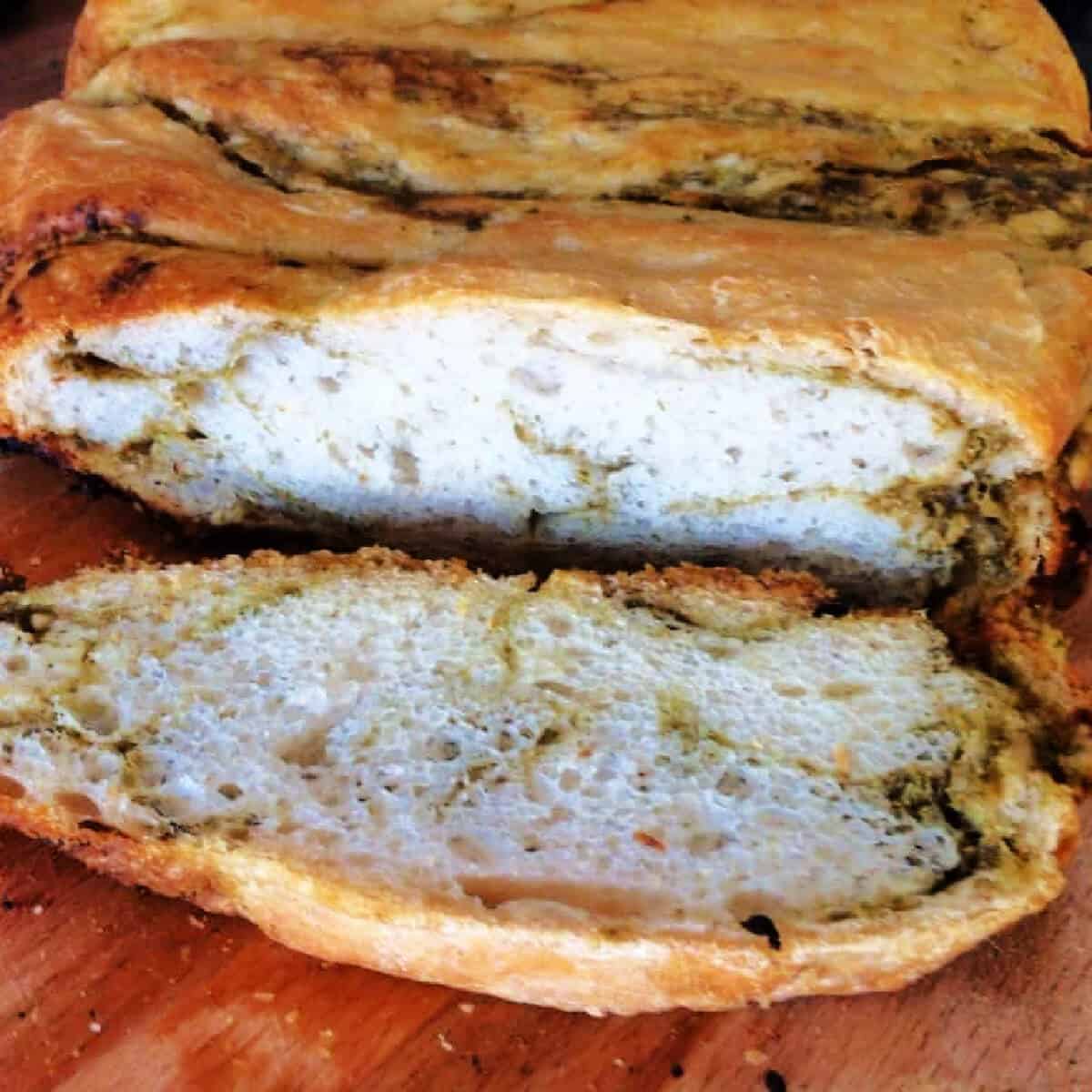 Bread rippled with pesto, cut open to show the interior of the loaf.