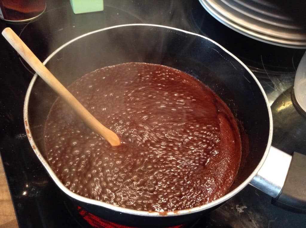 Making chocolate syrup in saucepan, mixture boiling.