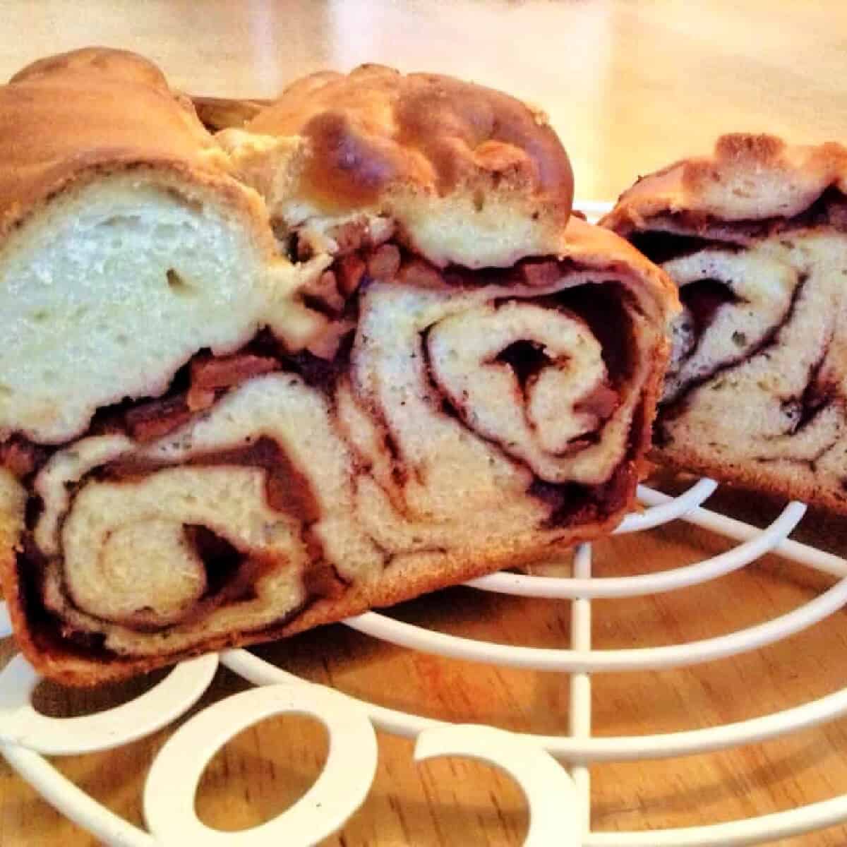 Swirled Povitica loaves on a white cooling rack.