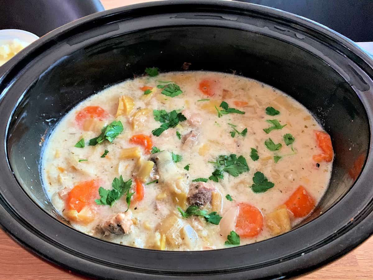 Creamy pork casserole in slow cooker pot, ready to serve.