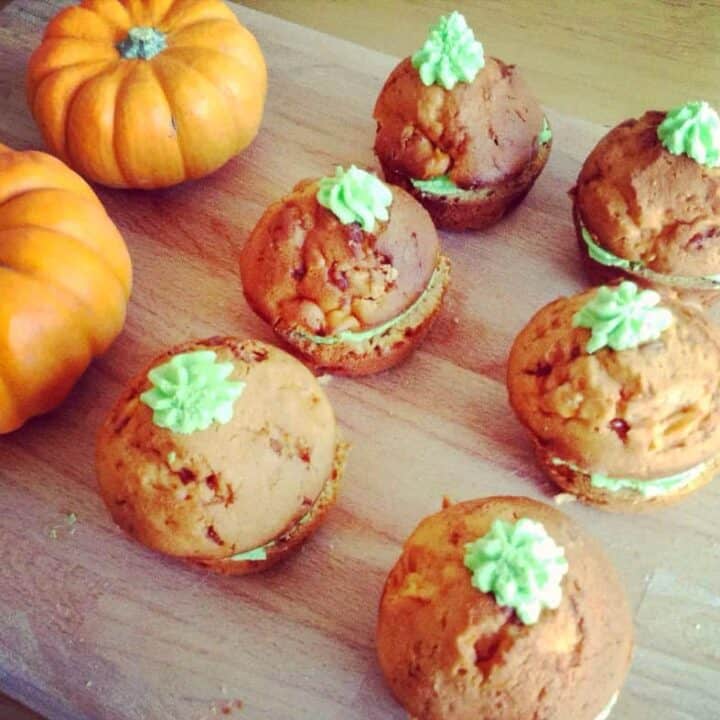 Orange cakes with green icing like pumpkins.