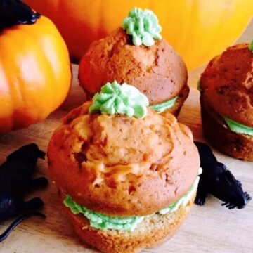 Orange cakes with green icing like pumpkins.