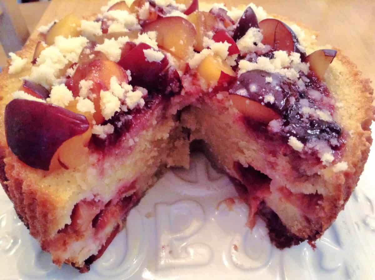 Plum and almond cake cut open to show the fruit pieces inside.
