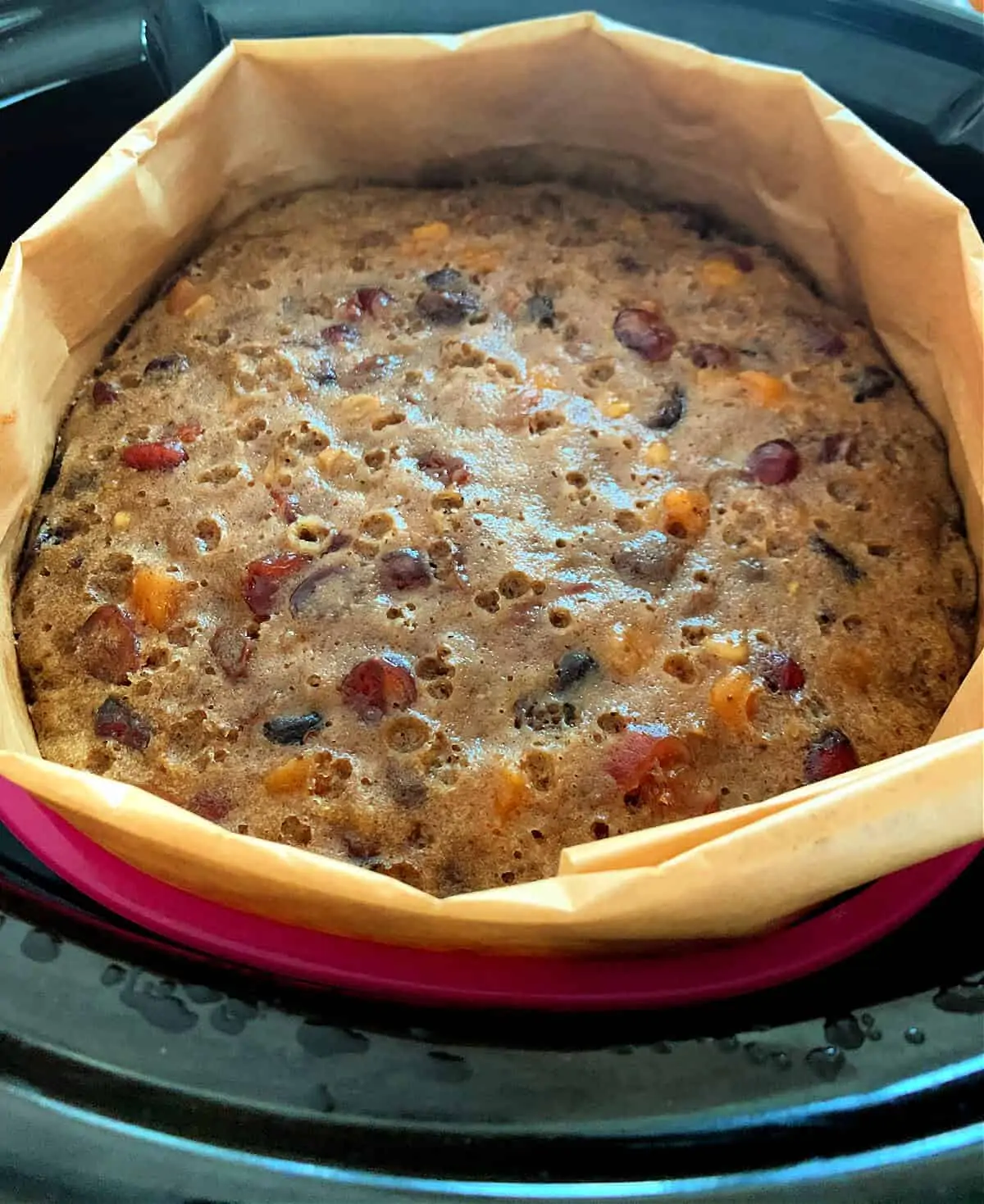Christmas Cake in lined silicone pan in slow cooker, after baking.