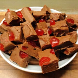 White plate with chopped up squares of chocolate cherry fudge.