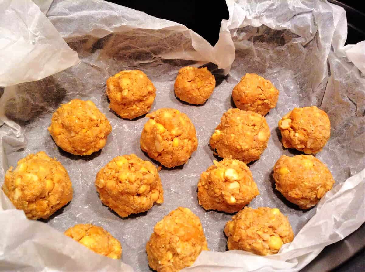 Uncooked falafel in lined slow cooker pot.