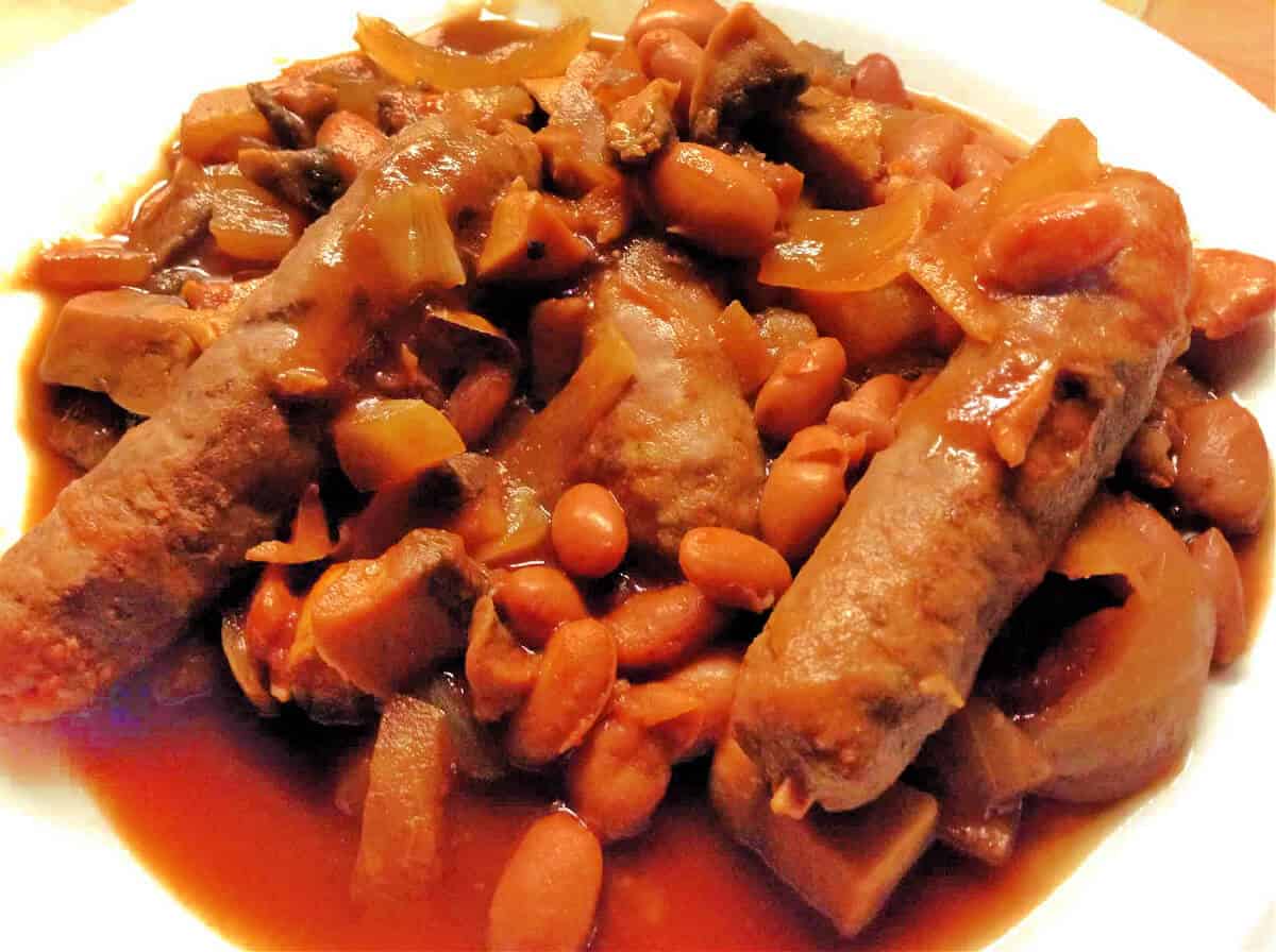 White plate with sausages and beans.