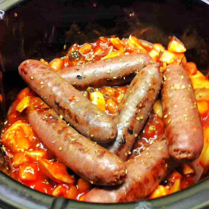 Sausages and beans in a slow cooker pot.