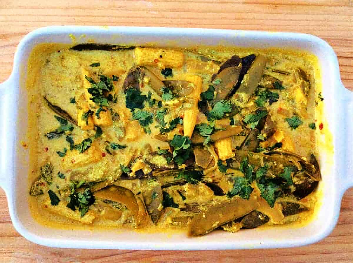 Malaysian vegetable curry with zingy yellow sauce in a white serving dish.