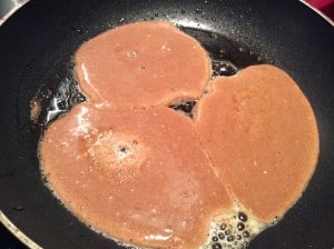 Pancakes cooking in a frying pan.