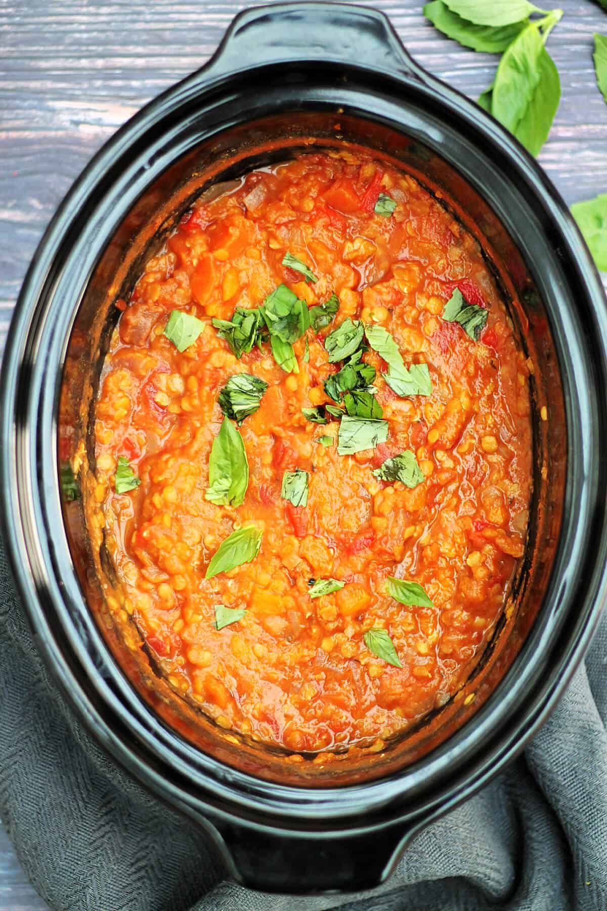 Slow cooker inner pot with red lentil pasta sauce.