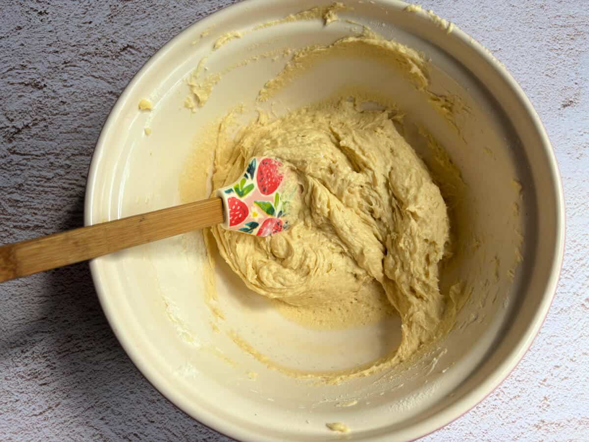 Cake mixture with flour folded in, with spatula in bowl.
