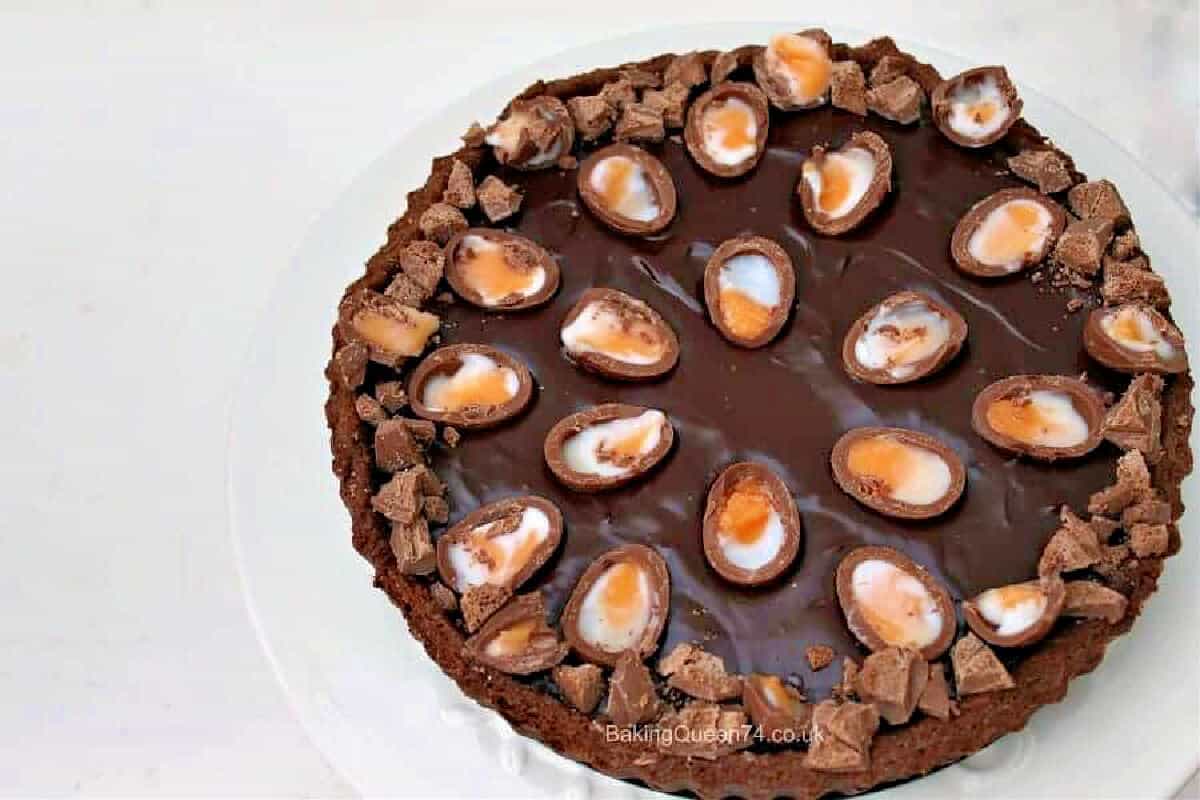 Creme Egg chocolate ganache tart on white plate.