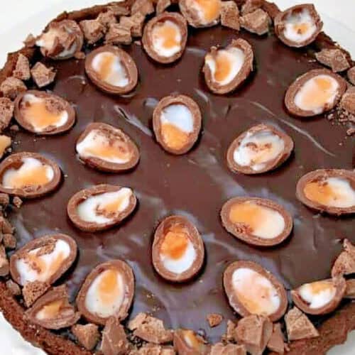 Close up of a chocolate tart with halved creme eggs on top.