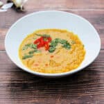 Bowl of dal with red chilli and chopped coriander/cilantro garnish.