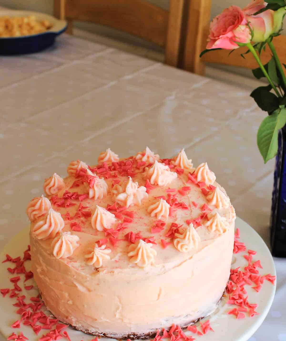 Pink birthday cake on white plate.