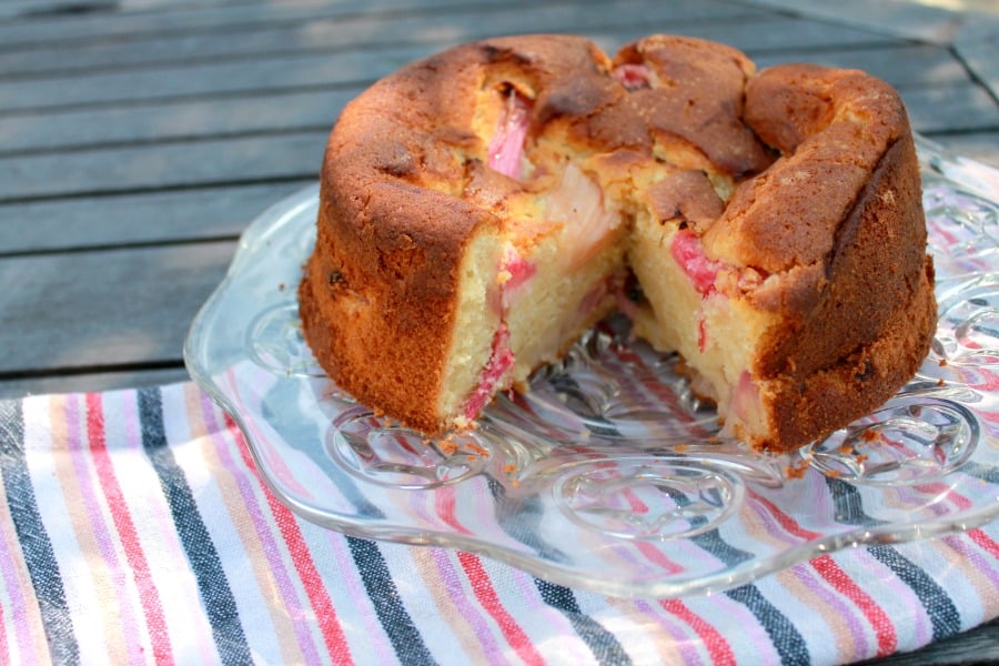 Rhubarb cake on a platter on a wooden table.