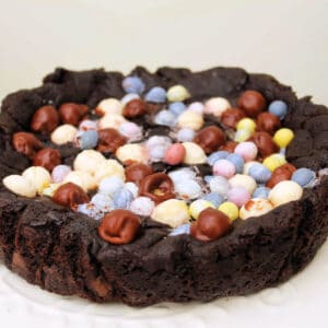 Chocolate cookie cake topped with small chocolate eggs.
