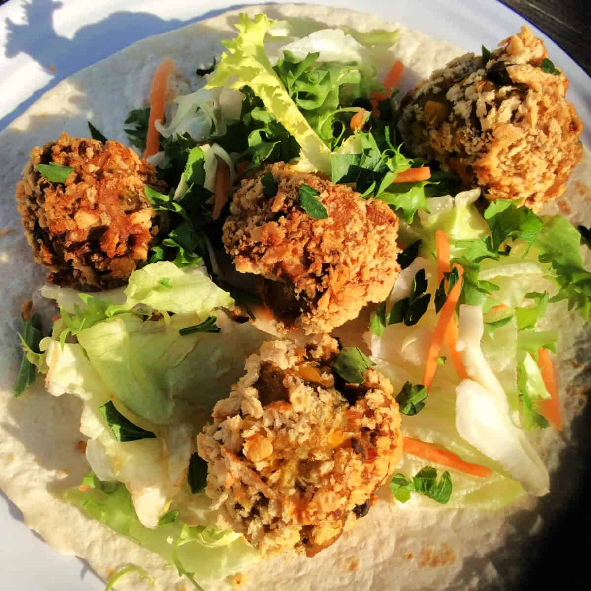 Croquettes with lettuce on a tortilla wrap.