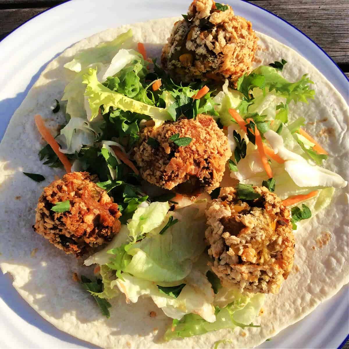 Croquettes with lettuce on a tortilla wrap.