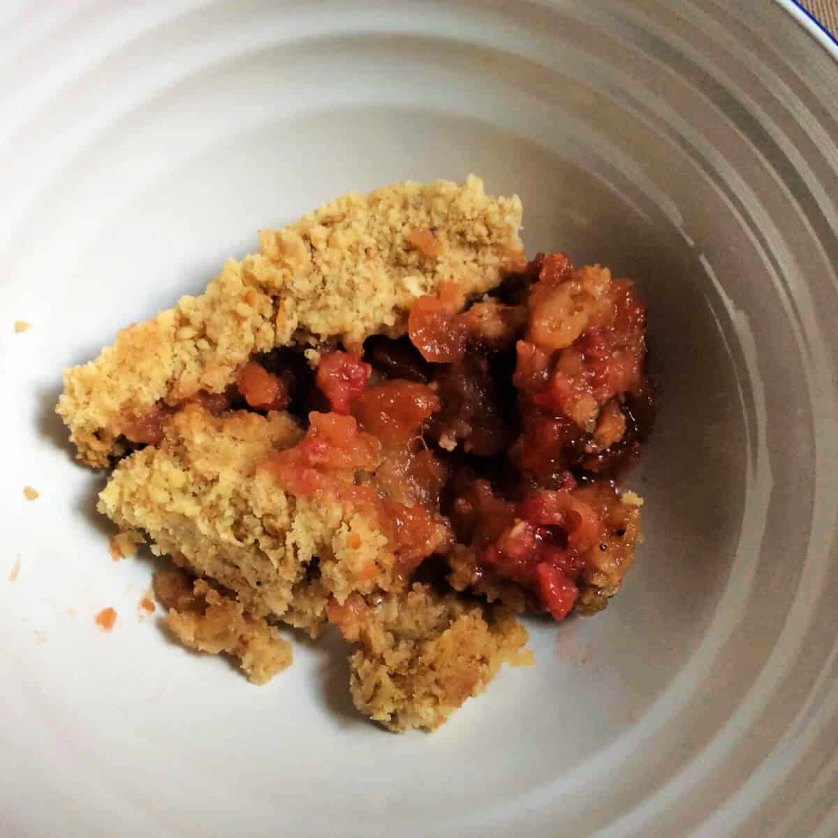 Bowl of slow cooker raspberry crumble, served.