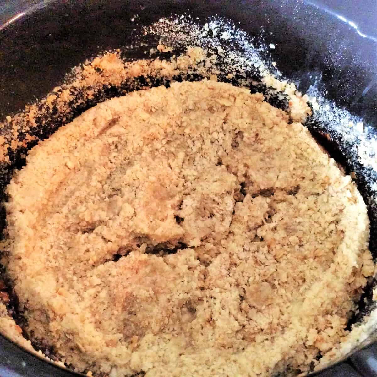Cooked crumble in a slow cooker pot.