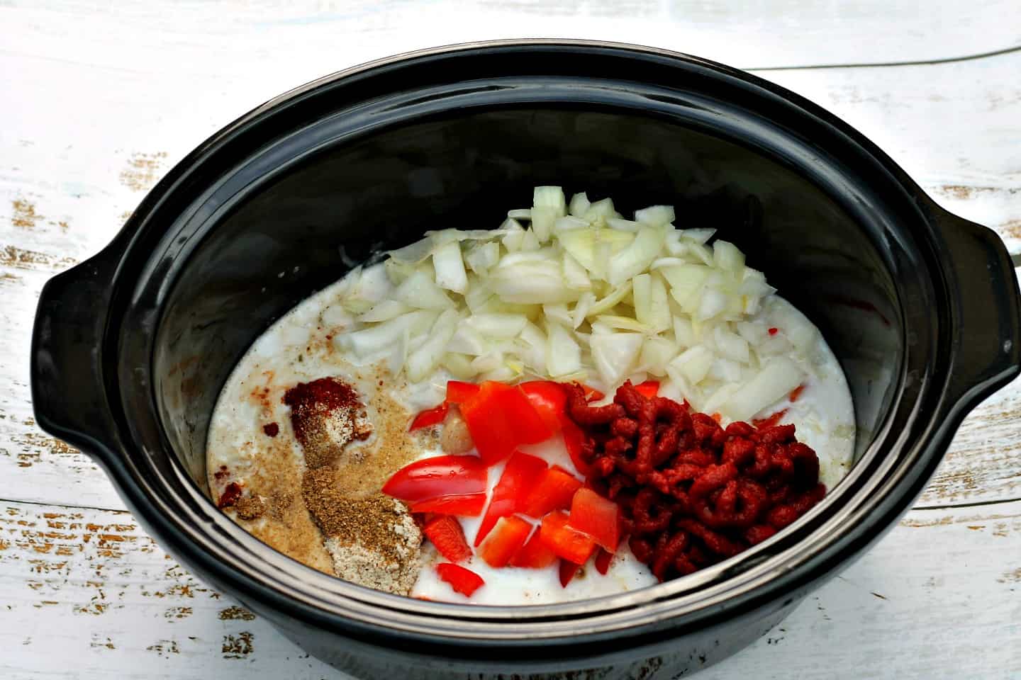 Slow cooker pot filled with curry ingredients.