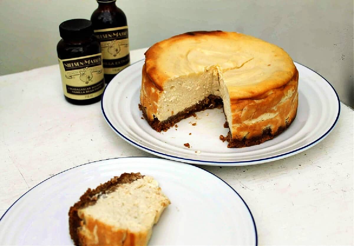 Cheesecake on a serving plate with one slice cut out on another plate.