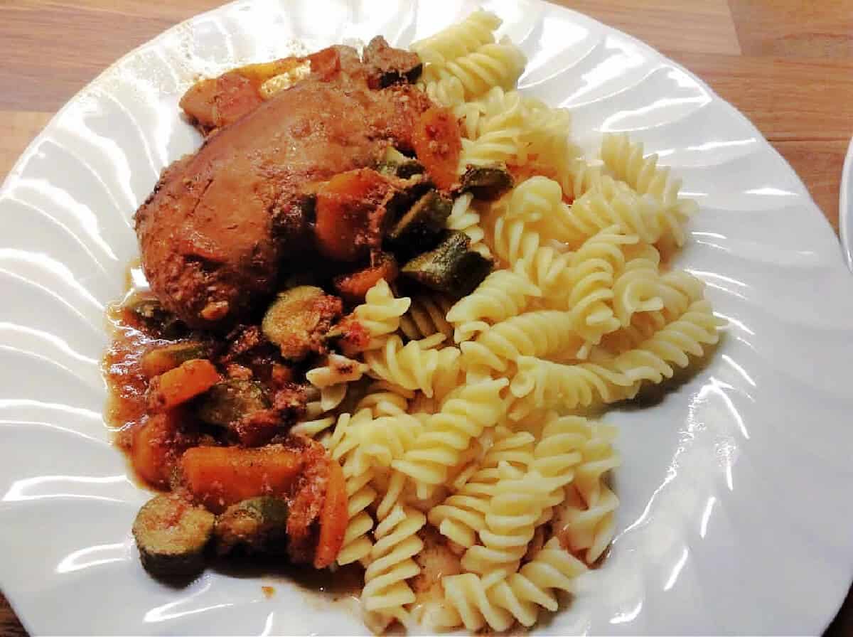 Plate with pasta and chicken and vegetable tagine.