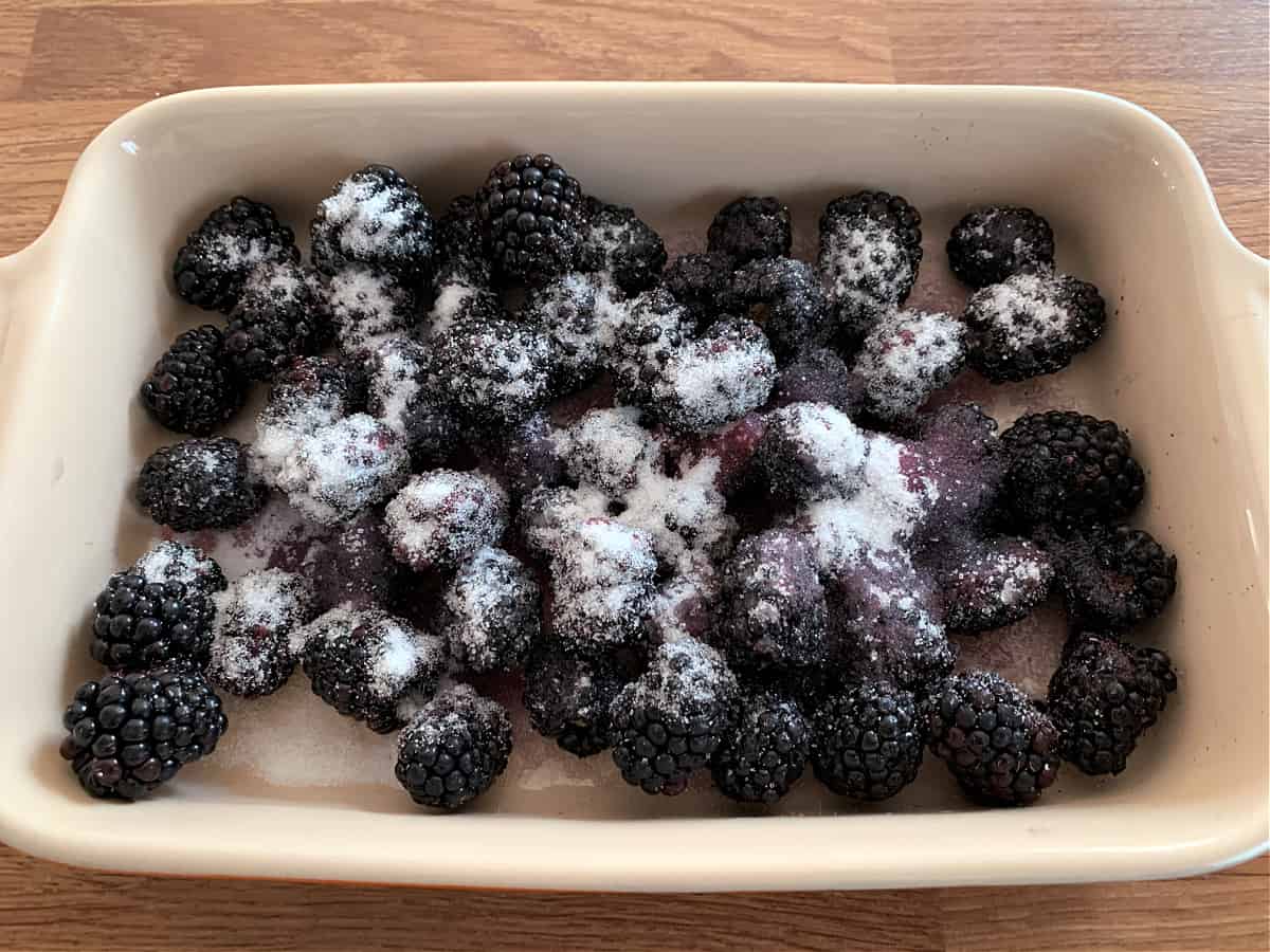 Blackberries sprinkled with sugar in a ceramic dish.